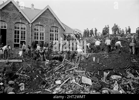 Aberfan, Südwales, um 21.. Oktober 1966 das Bild zeigt den Schlamm und die Verwüstungen, die verursacht wurden, als am 21.. Oktober 1966 die Bergbauschürze hoch über der Stadt herunterkam und die Pantglas Junior School verschlang. Retter, die versuchen, Opfer zu finden und zu helfen, monisten den Schlamm und die Trümmer um den Schulstandort herum. Die Katastrophe von Aberfan war ein katastrophaler Einsturz einer kollidierenden Beute im walisischen Dorf Aberfan, in der Nähe von Merthyr Tydfil. Es wurde durch eine Ansammlung von Wasser in den angesammelten Felsen und Schiefer verursacht, die plötzlich begann, in Form von Schlamm bergab zu rutschen und verschlang die Stockfoto