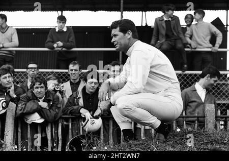 Dreharbeiten zum MGN-Film „Grand Prix“ bei Brands Hatch in Kent im Juli 1966. Schauspieler James Garner ist der amerikanische Grand-Prix-Fahrer Pete Aron, der von seinem Jordan-BRM-Rennteam gefeuert wird und für das japanische Yamura-Team fährt. Im Bild: Während der Dreharbeiten musste James Garner seinen Rennwagen (kein Stunt-Mann) für 1/2 eine Meile rund um Brands Hatch Circuit fahren, während er in Brand war. James hielt kurz nach der Ziellinie an und sprang aus dem Cockpit, als Flammen das Auto umschlingen. Feuerwehrmänner waren bereit, die Flammen zu löschen. James Garner ist während der Dreharbeiten zu diesem Film für £1million versichert. Stockfoto