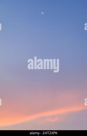 Traumhimmel bei Sonnenuntergang mit Mond und rosa Wolken. Frankreich. Stockfoto