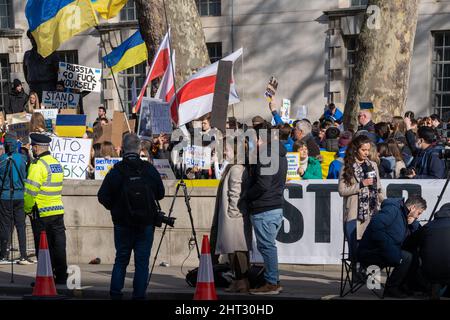 London, Großbritannien, 26.. Februar 2022, Anti-Kriegs-Demonstranten, die mit ukrainischen Fahnen drapiert waren, waren Teil von Hunderten, die sich in Whitehall bei einer Kundgebung und Demonstration versammelten Stockfoto