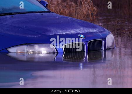 Spiegelungen eines BMW, der auf der Newton Lane in der Nähe von Castleford, West Yorkshire, in Wasser getaucht war, nachdem Sturm Franklin viele Teile Großbritanniens überschwemmt hatte Stockfoto