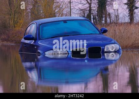 Spiegelungen eines BMW, der auf der Newton Lane in der Nähe von Castleford, West Yorkshire, in Wasser getaucht war, nachdem Sturm Franklin viele Teile Großbritanniens überschwemmt hatte Stockfoto