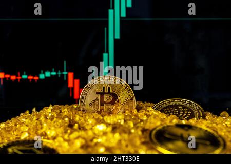 Nizza, Frankreich - 26.02.2022: Münze von Bitcoin und Altmünzen auf dem Goldkristall-Mineralsteinberg. Hintergrund für das Aktienwachstum verschwommen. Das Diagramm zeigt einen starken Anstieg des Bitcoin-Preises. Stockfoto