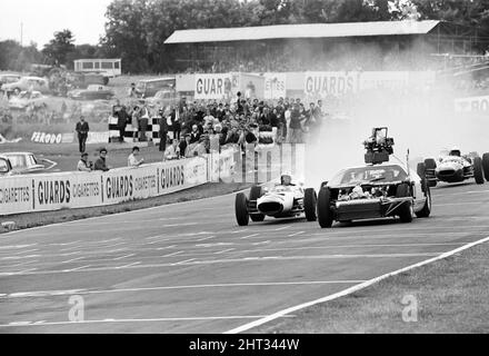 Dreharbeiten zum MGN-Film „Grand Prix“ bei Brands Hatch in Kent im Juli 1966. Schauspieler James Garner ist der amerikanische Grand-Prix-Fahrer Pete Aron, der von seinem Jordan-BRM-Rennteam gefeuert wird und für das japanische Yamura-Team fährt. Im Bild: Während der Dreharbeiten musste James Garner seinen Rennwagen (kein Stunt-Mann) für 1/2 eine Meile rund um Brands Hatch Circuit fahren, während er in Brand war. James hielt kurz nach der Ziellinie an und sprang aus dem Cockpit, als Flammen das Auto umschlingen. Feuerwehrmänner waren bereit, die Flammen zu löschen. James Garner ist während der Dreharbeiten zu diesem Film für £1million versichert. Stockfoto