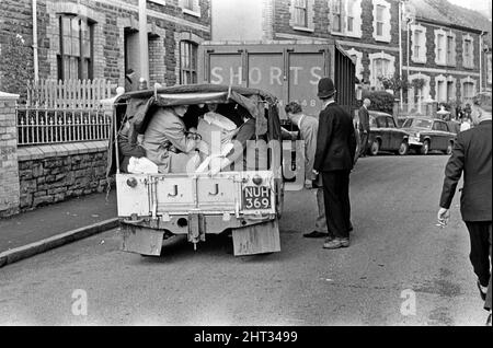 Aberfan, Südwales, um 21.. Oktober 1966 Einheimische Dorfbewohner helfen sich gegenseitig, indem sie sich in den Fahrzeugen, die ihnen zur Verfügung stehen, gegenseitig besetzen, um Vorräte zu liefern und die Menschen in Sicherheit zu bringen. Die Katastrophe von Aberfan war ein katastrophaler Einsturz einer kollidierenden Beute im walisischen Dorf Aberfan, in der Nähe von Merthyr Tydfil. Er wurde durch eine Ansammlung von Wasser im angesammelten Fels und Schiefer verursacht, die plötzlich in Form von Schlamm bergab zu rutschen begann und am 21.. Oktober 1966 die Pantglas Junior School darunter verschlang und 116 Kinder und 28 Erwachsene tötete. Das ursprüngliche Schulgelände ist heute ein Gedenkgarten. Pi Stockfoto