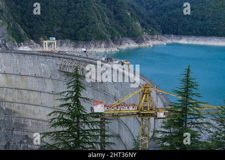 Das größte Wasserkraftwerk im Kaukasus, das sich am Fluss Inguri befindet. Blick auf den Damm und den Stausee mit türkisfarbenem Wasser. Gegen die Stockfoto