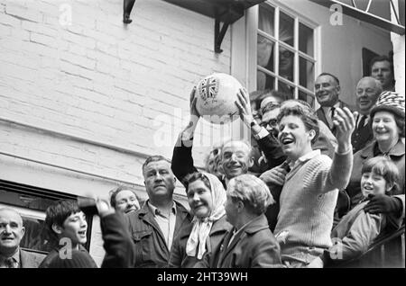 Das traditionelle Royal Shrovetide Football Match, ein „mittelalterliches Fußballspiel“, das jährlich am Faschingsdienstag und Aschermittwoch in der Stadt Ashbourne in Derbyshire gespielt wird. Ehrengast Sir Stanley Matthews mit lokalen Dorfbewohnern vor Beginn des Spiels. 22.. Februar 1966. Stockfoto