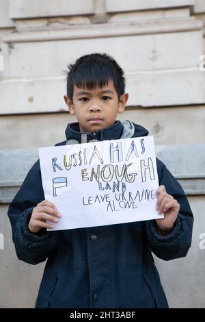 London, Großbritannien, 26.. Feb 2022 Ein kleiner Junge hält ein Schild in Whitehall, wo sich Hausangestellte versammelt haben, um gegen den jüngsten Angriff Russlands auf die Ukraine zu protestieren. Stockfoto