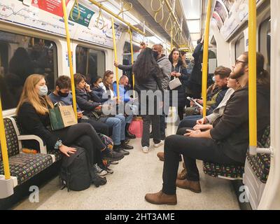 London, Großbritannien, 26. Februar 2022: Gesichtsmasken sind jetzt in öffentlichen Verkehrsmitteln optional, aber in diesem Zug der Circle Line auf der Londoner U-Bahn ziehen viele Menschen sie immer noch an. Anna Watson/Alamy Live News Stockfoto