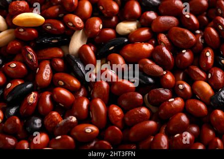 Getrocknete rote Bohnen und schwarze, weiße Mischung auf rustikalem Tisch. Stockfoto
