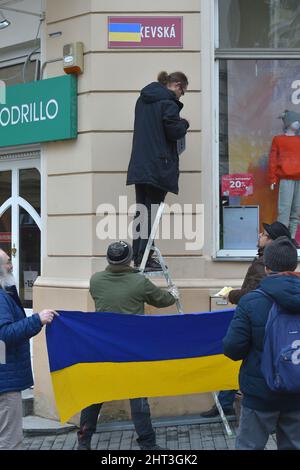 Karlsbad, Tschechische Republik. 26.. Februar 2022. Ein Aktivist setzte während einer Demonstration zur Unterstützung der Ukraine in Karlovy Vary, Tschechische Republik, am 26. Februar 2022 die ukrainische Flagge auf ein Schild mit der Aufschrift Moscow Street. Kredit: Slawomir Kubes/CTK Foto/Alamy Live Nachrichten Stockfoto