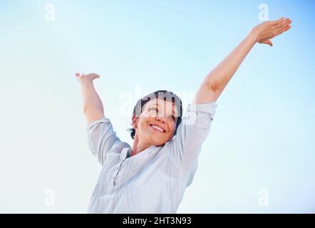 Frau genießt die Freiheit. Low-Angle-Ansicht schöne reife Frau genießen Freiheit im Freien mit ausgestreckten Armen. Stockfoto
