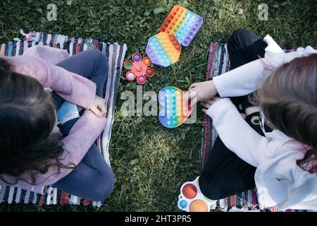 Kinder ziehen die Hände, um Spielzeug zu knallen Stockfoto