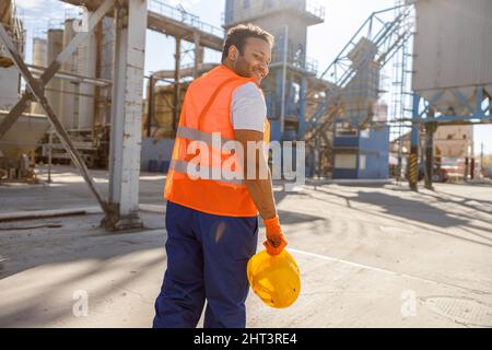 Foto eines Mannes, der hart in der Fabrik für Baustoffe arbeitet Stockfoto