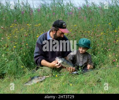 Mann und Kind mit Barschfängen Stockfoto