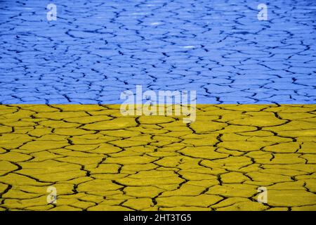 Rissige trockene Erde in den Nationalfarben der ukrainischen Flagge Stockfoto