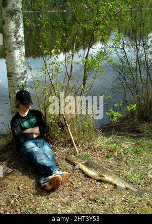 Der Junge macht eine Angelpause nach Birke Stockfoto