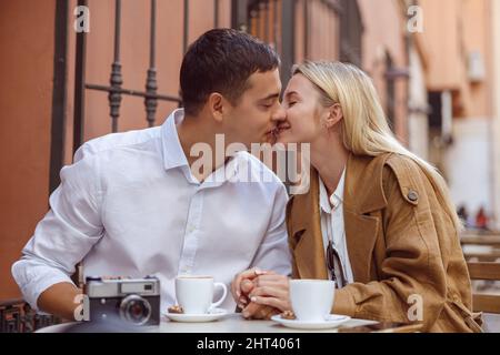 Portrait eines küssenden Paares, das im Café sitzt Stockfoto