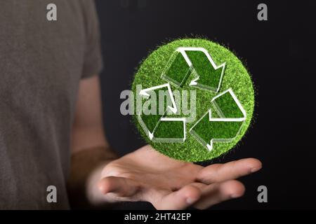 Person, die eine virtuelle Projektion des Recycling-Symbols präsentiert Stockfoto