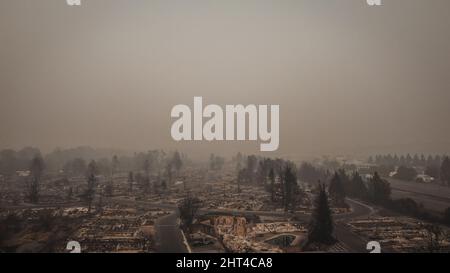 Rauchgefüllter Himmel mit Blick auf die Nachwirkungen und die Tragödie eines Waldfeuers, das durch die Kleinstadt wehte Stockfoto