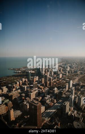 Vertikale Aufnahme von modernen Gebäuden, die an einem sonnigen Tag in Chicago, USA, vom Meer umgeben sind Stockfoto