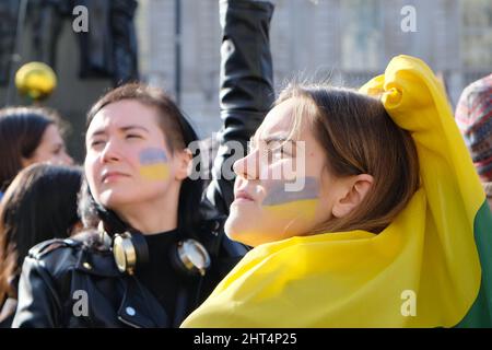 London, Großbritannien, 26.. Februar 2022, zwei Frauen mit ukrainischer Flagge auf ihren Wangen stehen mit Hunderten von anderen in Whitehall zusammen, um gegen die ukrainische Invasion zu demonstrieren und zu verstärkten Wirtschaftssanktionen zu rufen, wie zum Beispiel den Zugang zu dem Swift-Zahlungssystem, das den russischen Banken verhängt werden soll. Kredit: Elfte Stunde Fotografie/Alamy Live Nachrichten Stockfoto