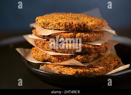 Stapel hausgemachter Gemüse-Burger-Patties, getrennt durch Pergamentpapier Stockfoto