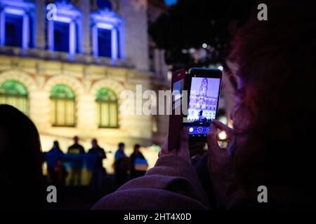 Porto, Portugal. 25.. Februar 2022. Ein Protestler sah während der Demonstration, wie er mit seinem Telefon Fotos machte. Friedlicher Protest auf dem Aliados-Platz in Porto zur Unterstützung der Ukrainer am Nachmittag. Kredit: SOPA Images Limited/Alamy Live Nachrichten Stockfoto