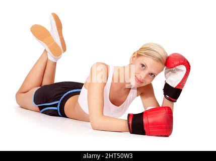 Shes a knock out. Porträt einer schönen Frau, die mit Boxhandschuhen auf dem Boden liegt. Stockfoto