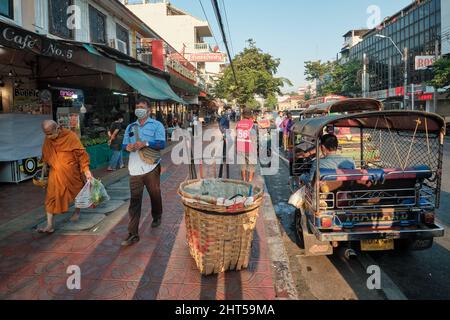 Straßenszene mit einem buddhistischen Mönch und Tuk-Tuks (Dreirad-Taxis) auf dem Pak Klong Talat (Markt), Bangkok, Thailand Stockfoto