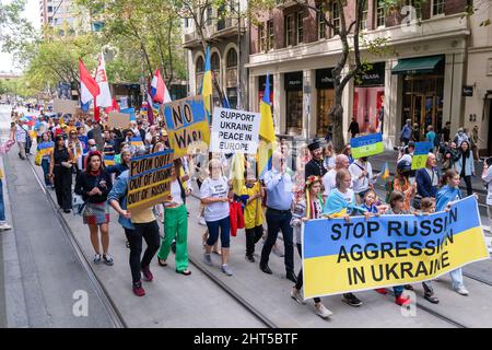 Melbourne, Australien, 27. Februar 2022. Demonstranten marschieren entlang der Collins Street während eines Protestes zur Unterstützung des Volkes und der Regierung der Ukraine angesichts einer russischen Invasion. Die Redner beteten und forderten die Lieferung von Waffen an die Ukraine und die Intervention der NATO und der Ungebundenen Nationen in Melbourne. Quelle: Michael Currie/Speed Media/Alamy Live News Stockfoto