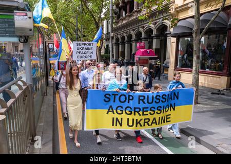 Melbourne, Australien, 27. Februar 2022. Demonstranten marschieren entlang der Collins Street während eines Protestes zur Unterstützung des Volkes und der Regierung der Ukraine angesichts einer russischen Invasion. Die Redner beteten und forderten die Lieferung von Waffen an die Ukraine und die Intervention der NATO und der Ungebundenen Nationen in Melbourne. Quelle: Michael Currie/Speed Media/Alamy Live News Stockfoto