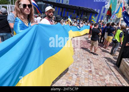 Melbourne, Australien, 27. Februar 2022. Demonstranten mit langer ukrainischer Flagge während eines Protestes zur Unterstützung des Volkes und der Regierung der Ukraine angesichts einer russischen Invasion. Die Redner beteten und forderten die Lieferung von Waffen an die Ukraine und die Intervention der NATO und der Ungebundenen Nationen in Melbourne. Quelle: Michael Currie/Speed Media/Alamy Live News Stockfoto