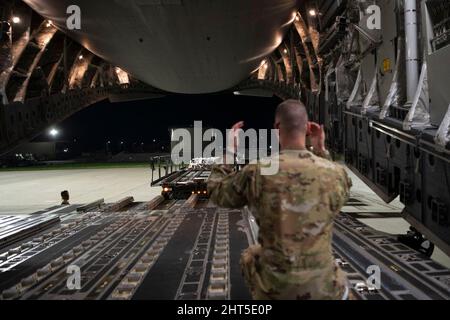 24. Februar 2022 - Travis Air Force Base, California, USA: US Air Force Airman 1. Class Chase Smith, 8. Airlift Squadron Ladermaster, Marshals einen K-Lader zu einem C-17 Globemaster III, der der Joint Base Lewis-McChord, Washington, auf der Travis Air Force Base, California, zugewiesen wurde, 14. Februar 2022. U.S. Airmen mit der 60. Aerial Port Squadron und 8. Airlift Squadron luden Ladung auf die C-17. K-Lader werden verwendet, um Fracht in und aus Flugzeugen zu transportieren. Unter der Leitung der USA unter der Leitung des U.S. Transportation Command unterstützte der 60. Air Mobility Wing die 621. Eventualfälle Stockfoto