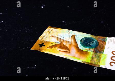 Nahaufnahme einer Schweizer Banknote von 100 auf schwarzer Oberfläche Stockfoto