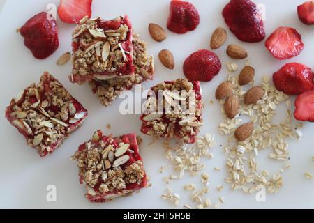 Erdbeer-Hafer-Mandeln, Frühstücksbar. Es gab kein Mehl-Frühstücksbar mit Haferflocken, Mandeln, Frischkäse und frischen Erdbeeren. Aufgenommen auf weißem Hintergrund Stockfoto