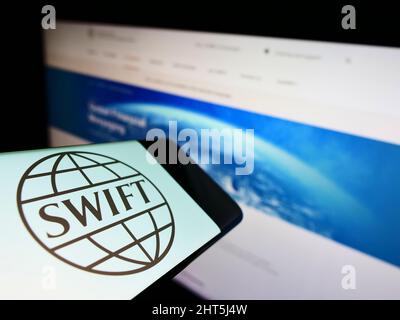 Mobiltelefon mit Logo des Banktransaktionssystems SWIFT auf dem Bildschirm vor der Website. Konzentrieren Sie sich auf die Mitte des Telefondisplays. Stockfoto