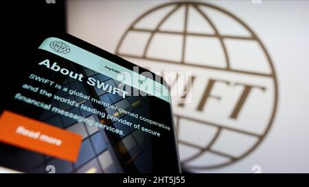 Mobiltelefon mit Webseite des Banktransaktionssystems SWIFT auf dem Bildschirm vor dem Logo. Konzentrieren Sie sich auf die obere linke Seite des Telefondisplays. Stockfoto