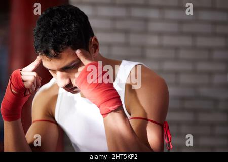 Sie müssen sich visualisieren, gewinnen. Ein junger Kämpfer, der sich mental auf einen Kampf vorbereitet. Stockfoto