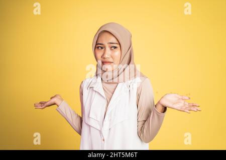 Verwirrte junge muslimische Frau, die beide Handflächen öffnete Stockfoto