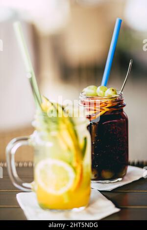 Vertikale Aufnahme von fertigen Limonaden mit Mango- und Traubengeschmack an der Bar. Stockfoto