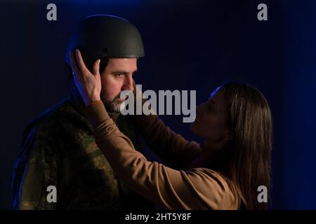 Eine traurige Frau, die sich von ihrem militärischen Ehemann verabschiedet, der im Krieg kämpfen wird. Stockfoto