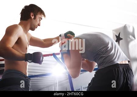 Deckung. Kurzer Schuss zweier Kampfkünstler, die im Ring spärten. Stockfoto