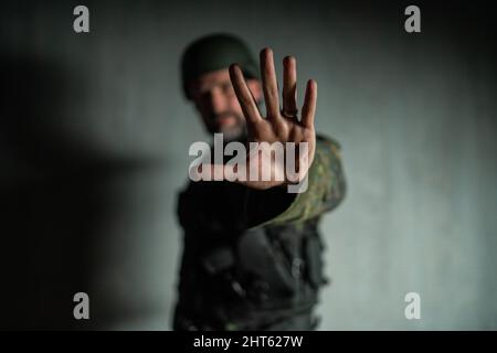 Frustrierter Soldat, der Hand zeigt, um den Krieg zu stoppen. Stockfoto