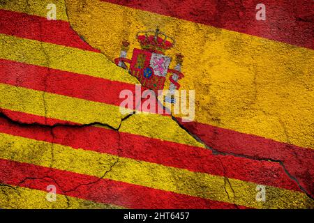 Vollformatfoto einer verwitterten Flagge Kataloniens und Spaniens, gemalt auf einer rissigen Wand. Stockfoto