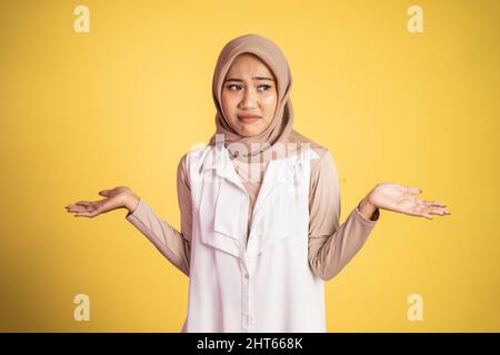 Verwirrte junge muslimische Frau, die beide Handflächen öffnete Stockfoto