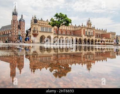 Häufige Regenschauer lassen die Altstadt von Krakau wie einen Spiegel aussehen, wenn es voll nass ist. Hier insbesondere Market Square, ein Wahrzeichen Stockfoto