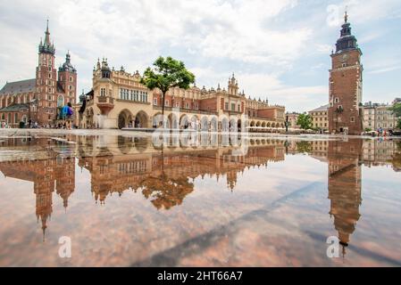 Häufige Regenschauer lassen die Altstadt von Krakau wie einen Spiegel aussehen, wenn es voll nass ist. Hier insbesondere Market Square, ein Wahrzeichen Stockfoto