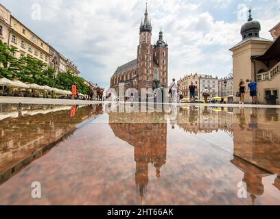 Häufige Regenschauer lassen die Altstadt von Krakau wie einen Spiegel aussehen, wenn es voll nass ist. Hier insbesondere Market Square, ein Wahrzeichen Stockfoto