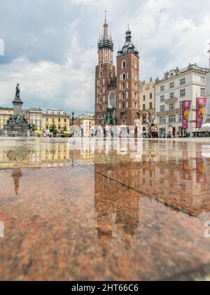 Häufige Regenschauer lassen die Altstadt von Krakau wie einen Spiegel aussehen, wenn es voll nass ist. Hier insbesondere Market Square, ein Wahrzeichen Stockfoto